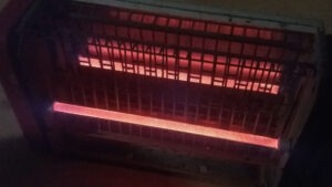 Photographie de l'intérieur d'un grille-pain. La résistance brille d'une couleur rouge orangé.